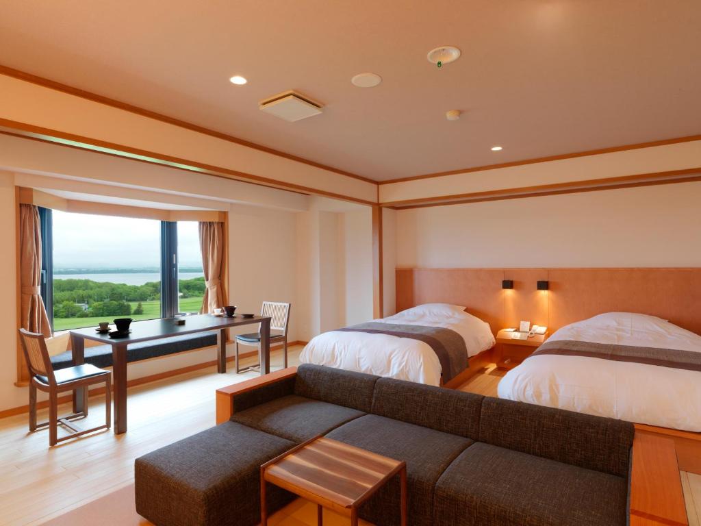 - une chambre avec 2 lits, un bureau et un canapé dans l'établissement Hokuten no Oka Abashiriko Tsuruga Resort, à Abashiri 37 autres photos