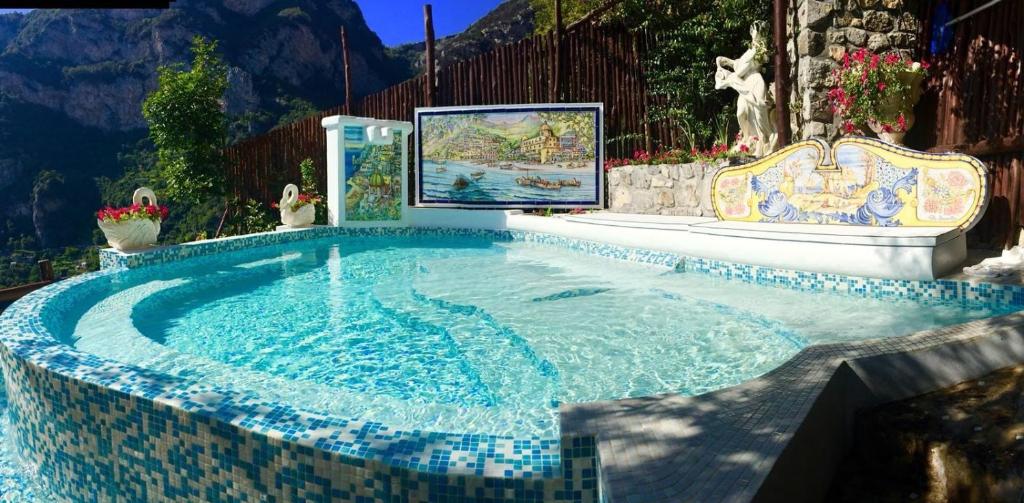 - une piscine avec du carrelage bleu et blanc dans l'établissement Villa Graziella Positano "a Piece of Paradise", à Positano