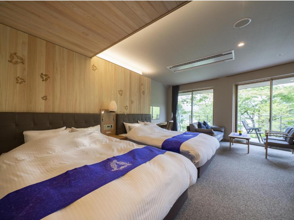 une chambre avec deux lits dans une pièce dans l'établissement Hotel Sekisuien, à Gujō