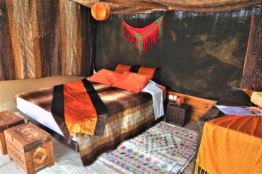 - une chambre avec un lit dans une chambre avec des rideaux dans l'établissement Riad Anma, à Taroudant