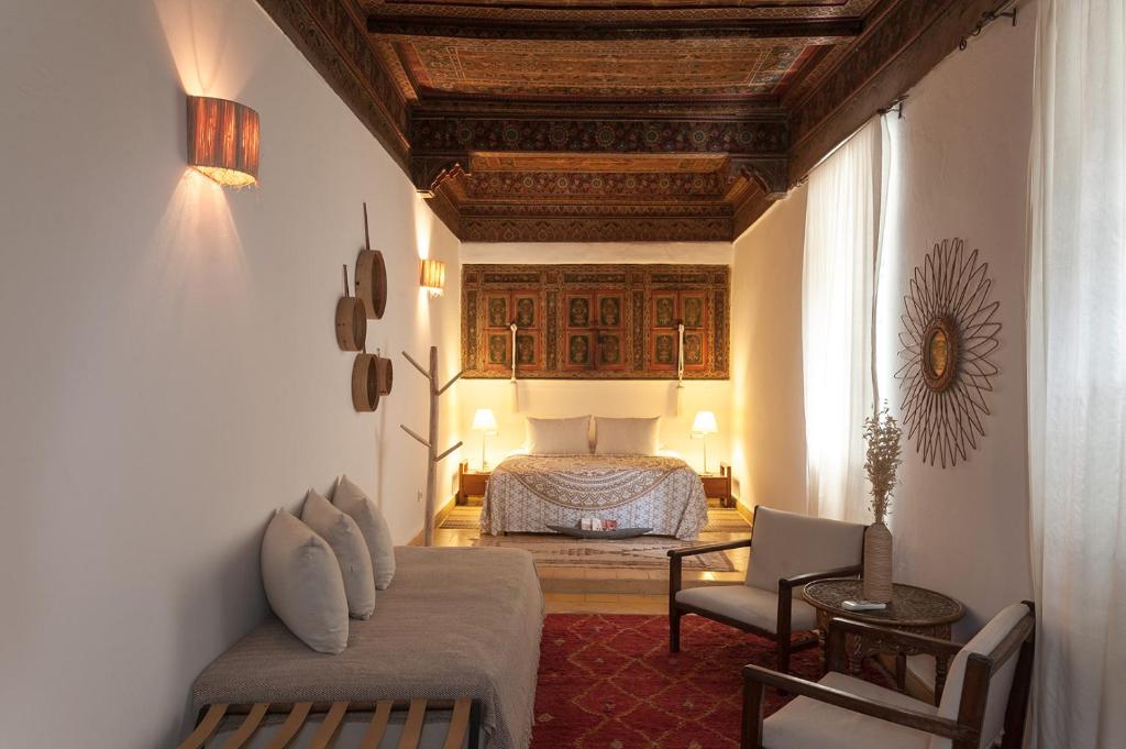une chambre avec un lit, un canapé et une chaise dans l'établissement Riad la Cle de la Medina, location en exclusivite, à Marrakech