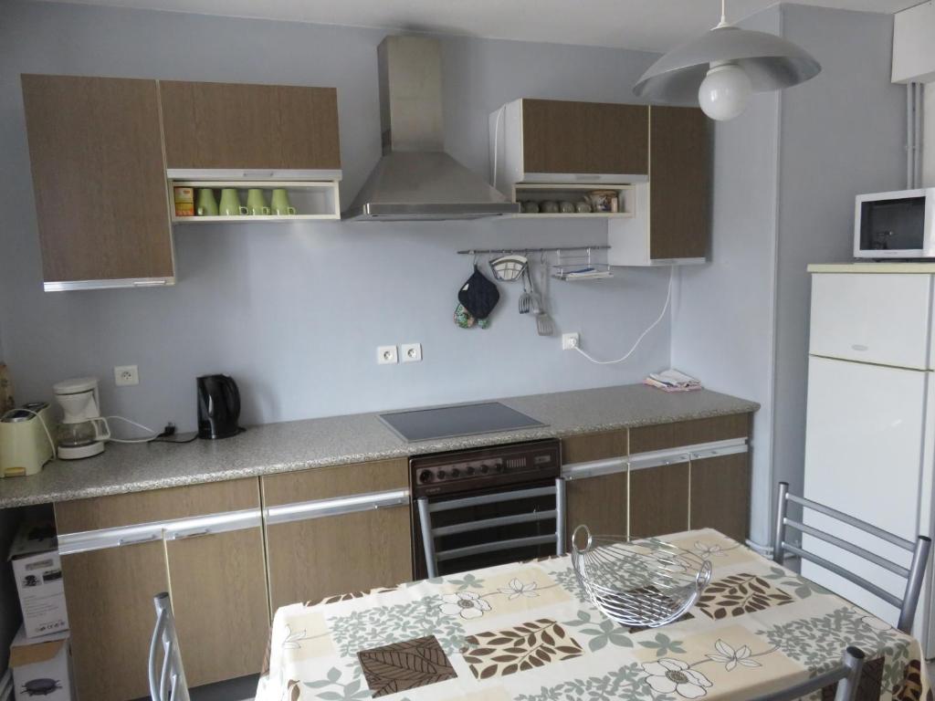 une cuisine avec une table et une cuisinière four supérieur dans l'établissement Gîtes vallée de Munster, à Muhlbach-sur-Munster