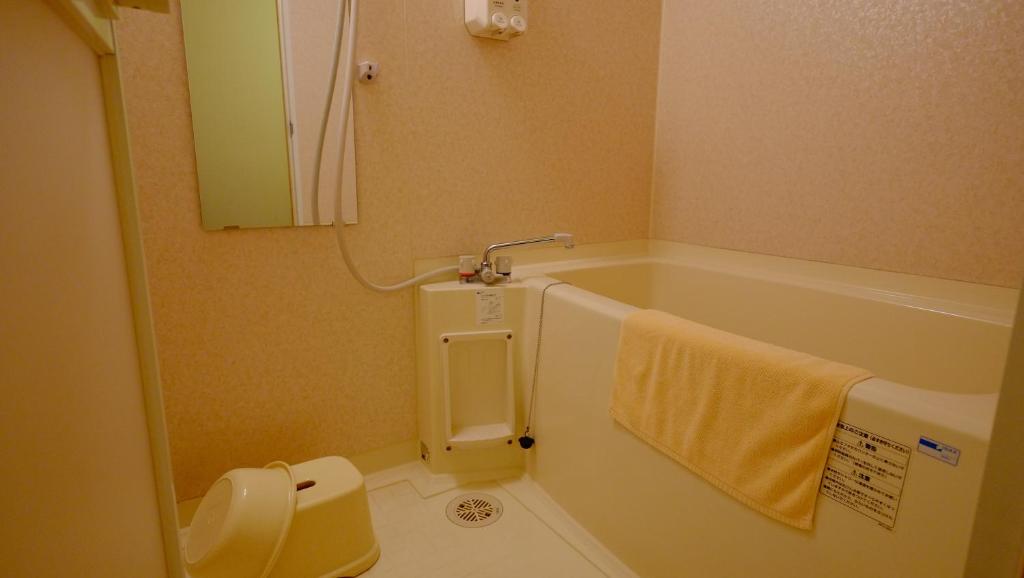 une salle de bain avec une baignoire, des toilettes et un lavabo dans l'établissement Okuhida Garden Hotel Yakedake, à Takayama
