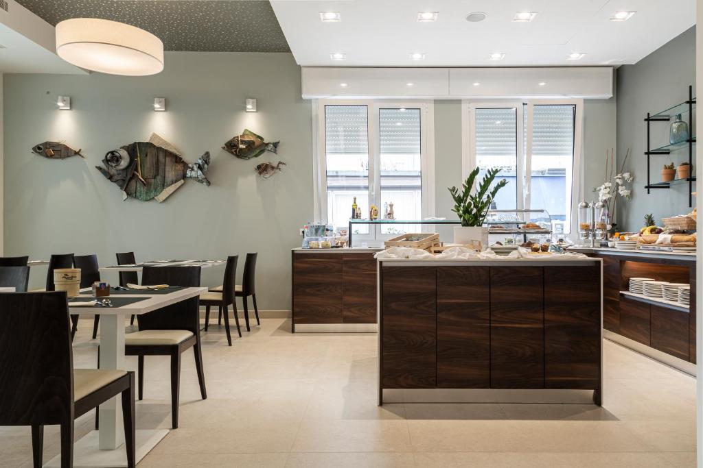 une cuisine et une salle à manger avec une table et des chaises dans l'établissement Hotel Mayer, à Lido di Jesolo