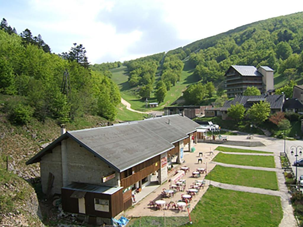 - une vue de tête sur un bâtiment avec des tables et des chaises dans l'établissement Col de Rousset - App. 2 P, à Rousset