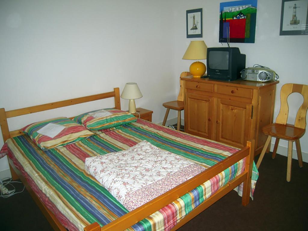 une chambre avec un lit et une commode avec une télévision dans l'établissement Col de Rousset - App. 2 P, à Rousset