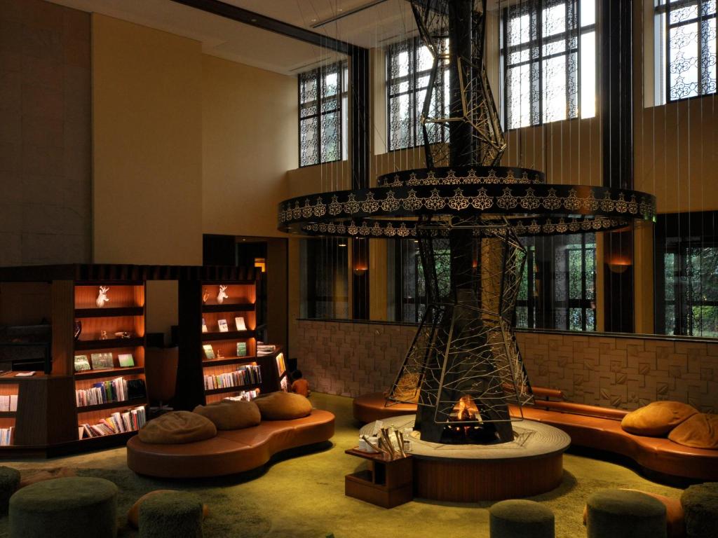 - une bibliothèque avec une cheminée au milieu d'une pièce dans l'établissement Jozankei Tsuruga Resort Spa Mori no Uta, à Jozankei