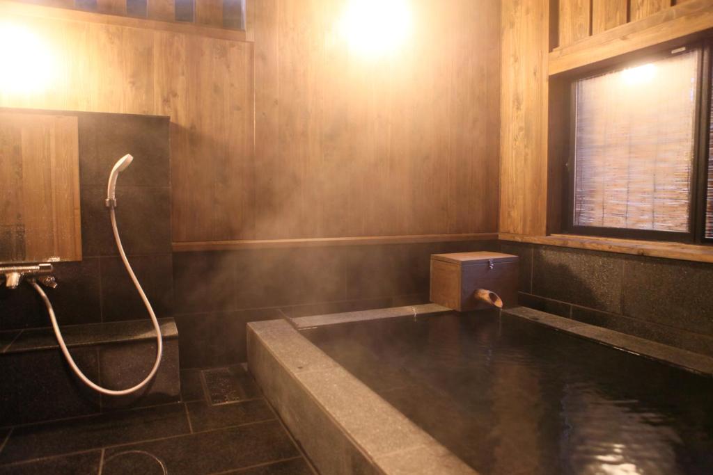 une salle de bain avec baignoire et douche dans l'établissement Ryokan Wakaba, à Minamioguni