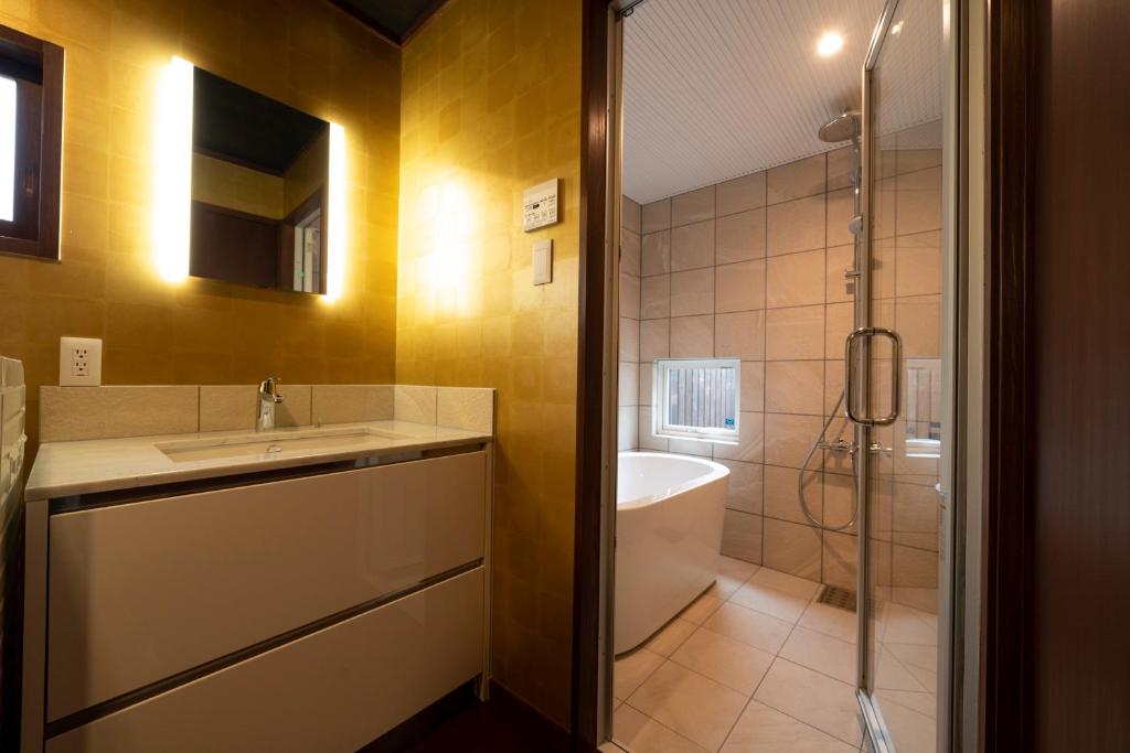 une salle de bain avec un lavabo, une douche et une baignoire dans l'établissement Iizukatei, à Nakagawa