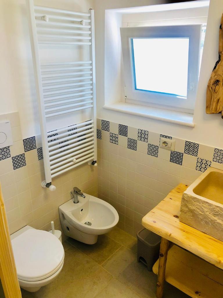 une salle de bain avec toilettes et lavabo dans l'établissement Trulli Paradise Alberobello, à Alberobello 24 autres photos