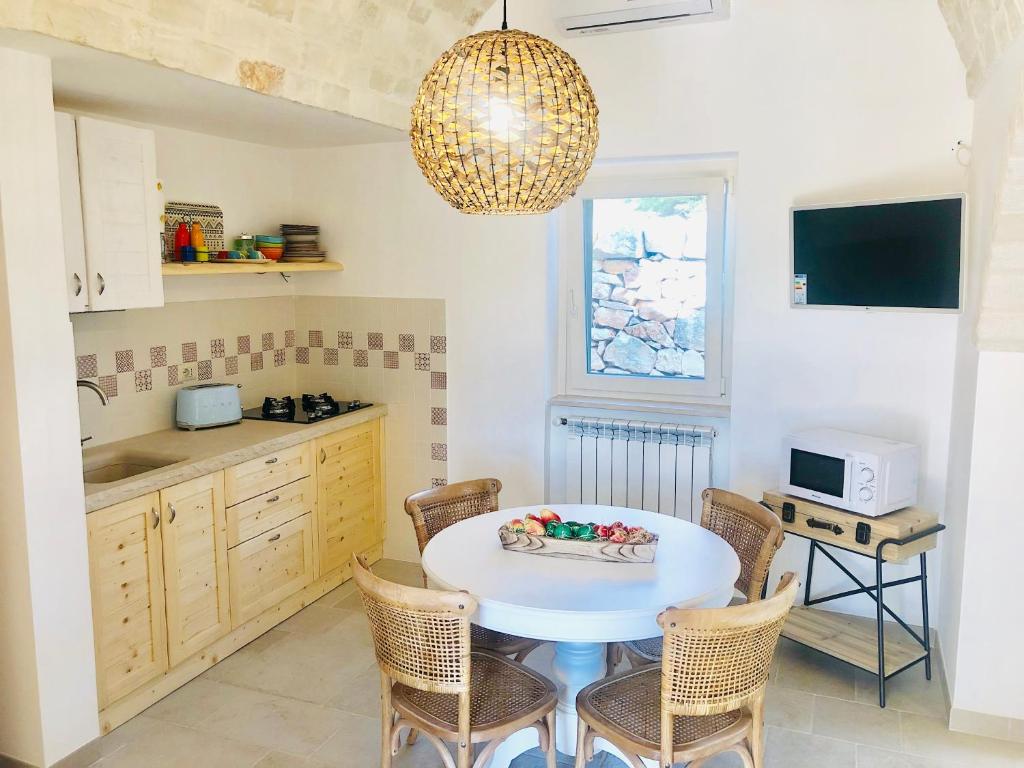 une cuisine avec une table et des chaises dans une cuisine dans l'établissement Trulli Paradise Alberobello, à Alberobello