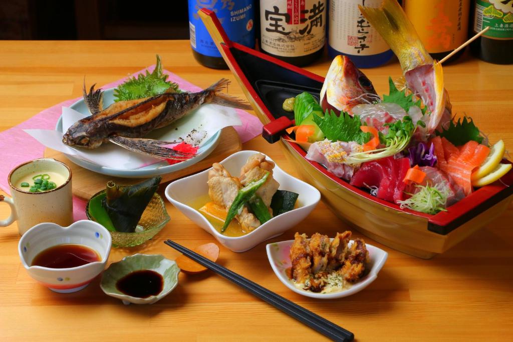une table avec des plats au-dessus d'une table dans l'établissement Tanegashima Minshuku Yuyu, à Minamitane 35 autres photos