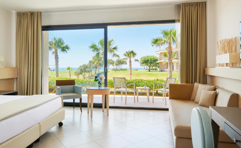 une chambre d'hôtel avec un lit et une vue sur l'océan dans l'établissement Capovaticano Resort Thalasso Spa, à Capo Vaticano