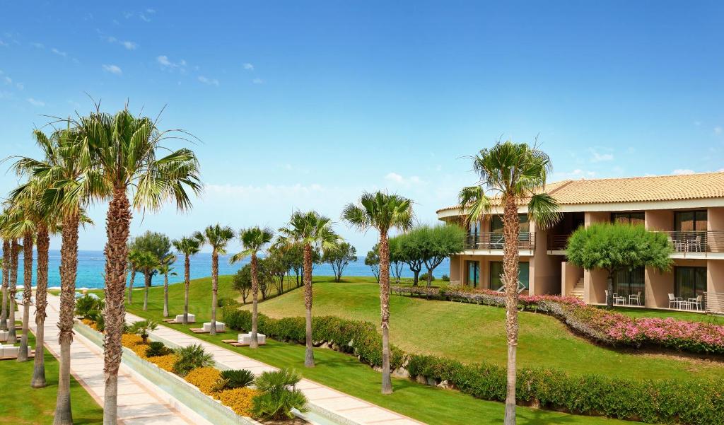 - une vue sur l'extérieur d'un complexe avec des palmiers dans l'établissement Capovaticano Resort Thalasso Spa, à Capo Vaticano