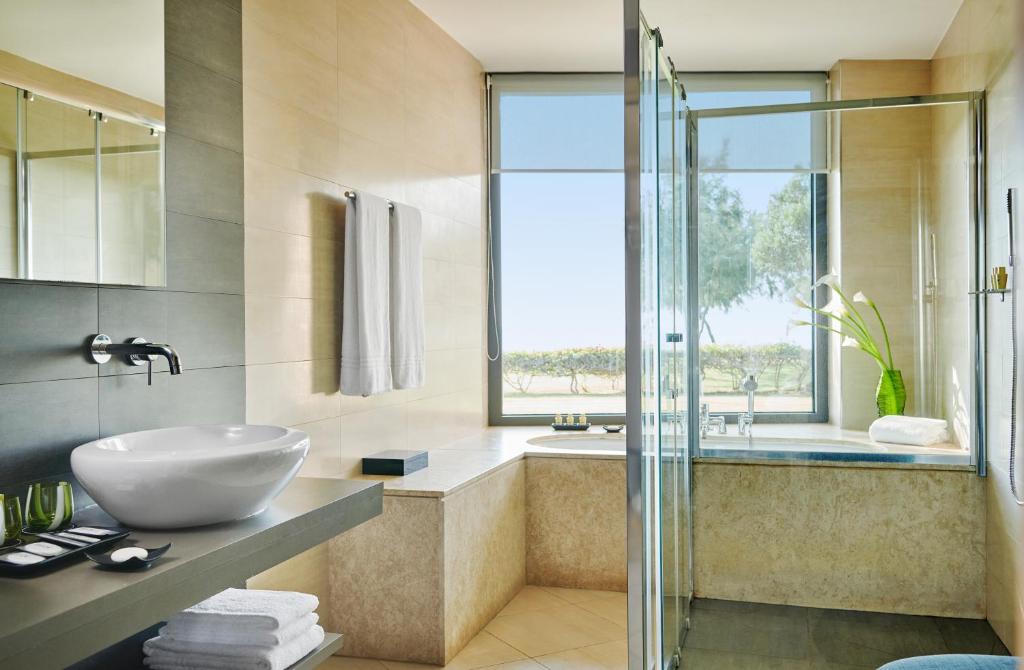 une salle de bain avec un lavabo et une douche en verre dans l'établissement Capovaticano Resort Thalasso Spa, à Capo Vaticano