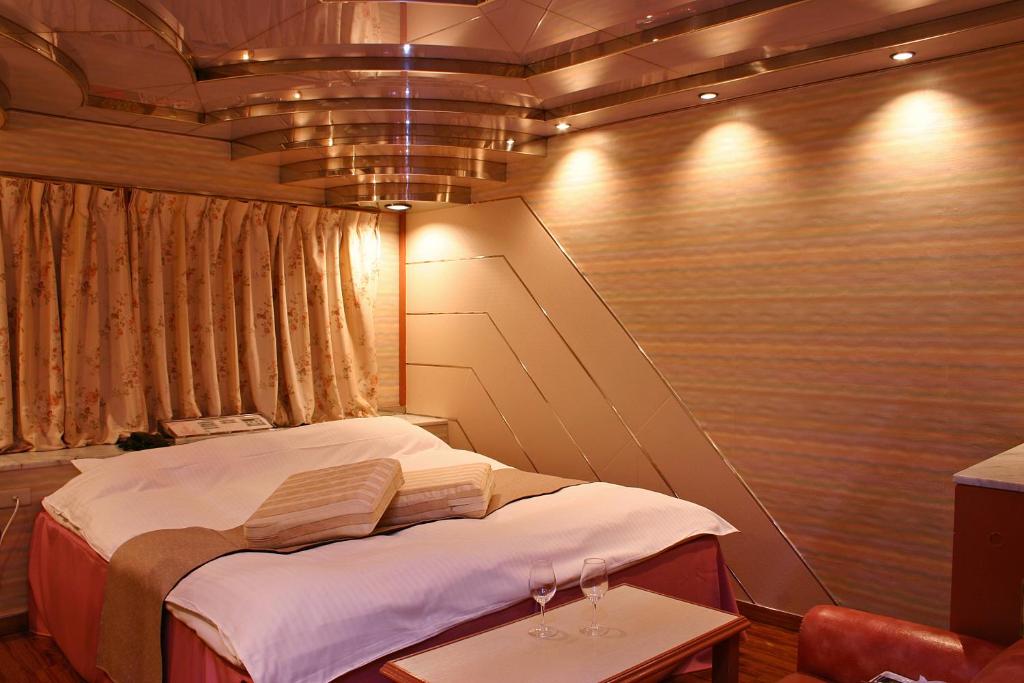 une petite chambre avec un lit dans une pièce dans l'établissement Hotel Chapel Story Sakaihigashi (Adult Only), à Sakai