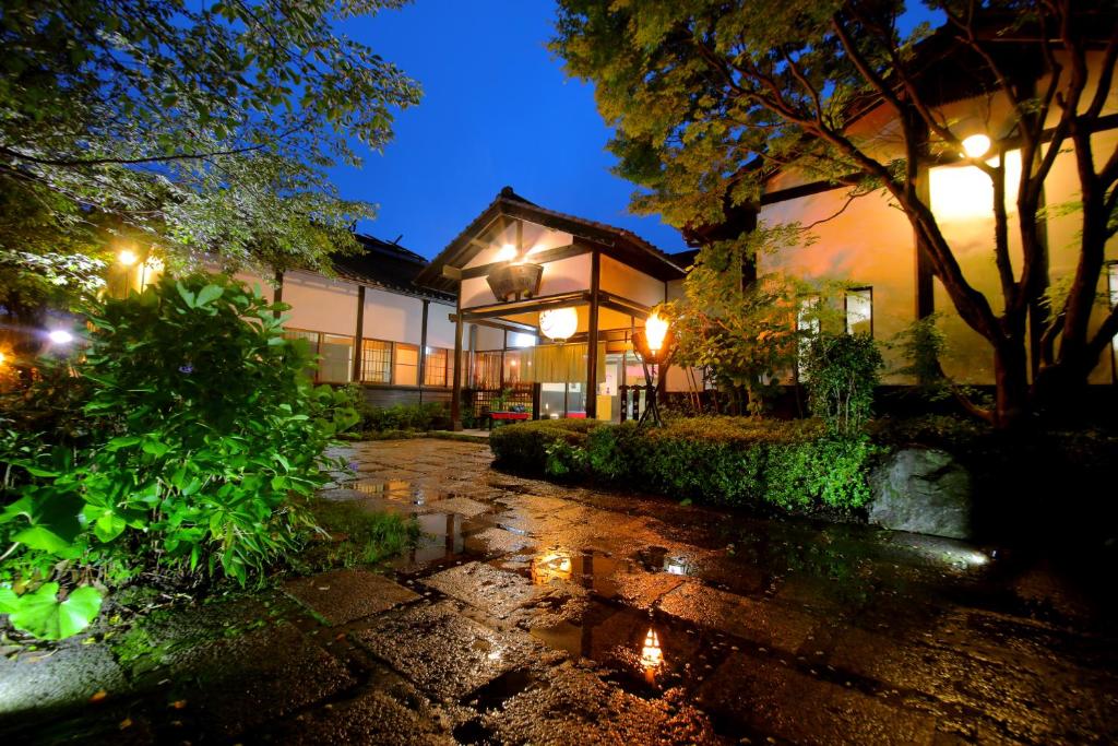 une maison la nuit avec une flaque d'eau dans l'établissement Sakura Sakura Onsen, à Kirishima