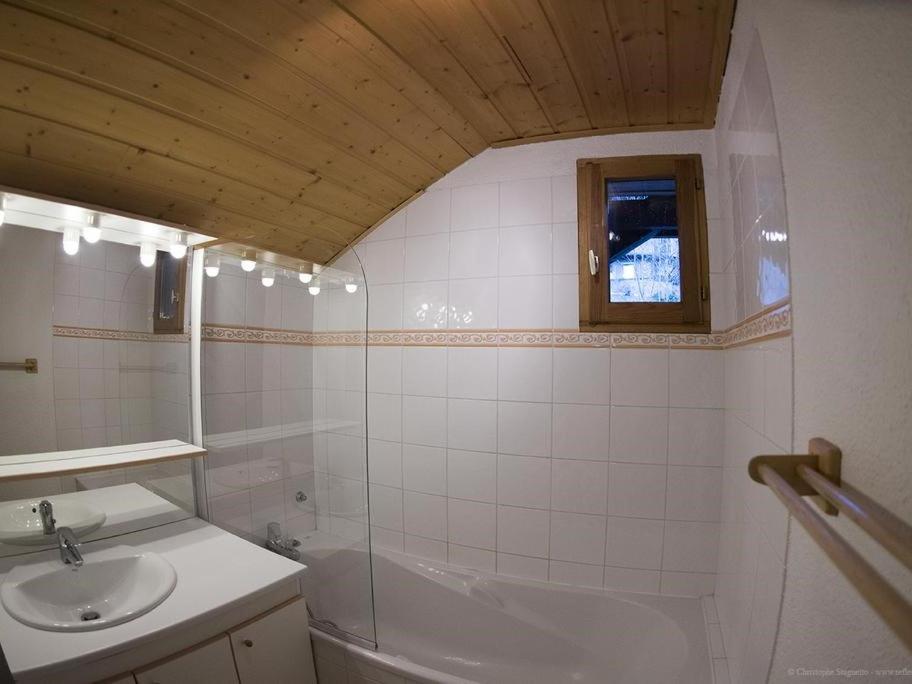 une salle de bain avec un lavabo et une baignoire dans l'établissement VAUJANYLOCATIONS - Chalet De Marie, à Vaujany
