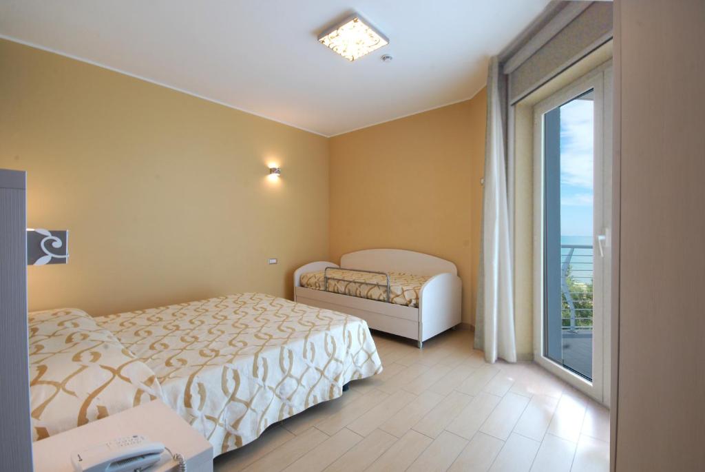 une chambre avec un lit et une grande fenêtre dans l'établissement Kiara Residence, à Giulianova