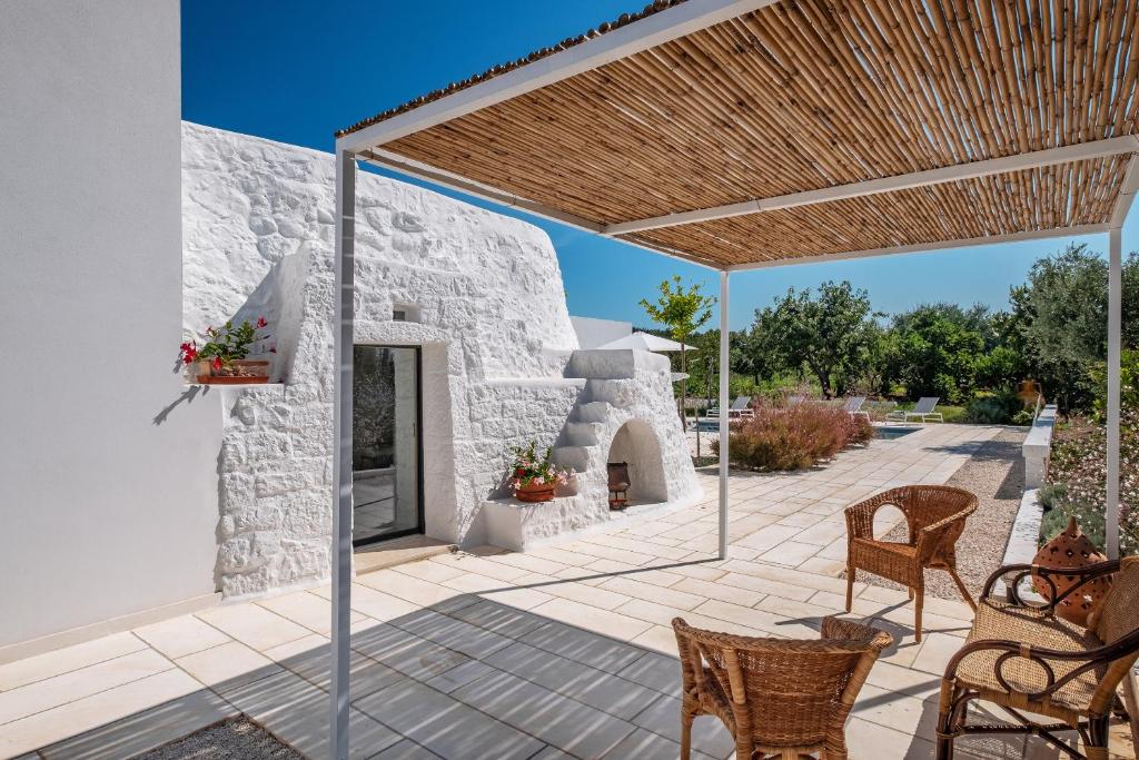 d'une terrasse avec des chaises et une cheminée en pierre. dans l'établissement Villa ELGAR, à Ostuni