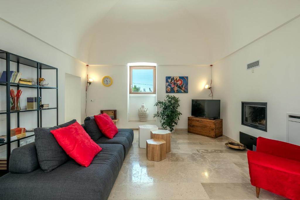 - un salon avec un canapé gris et des oreillers rouges dans l'établissement Villa ELGAR, à Ostuni