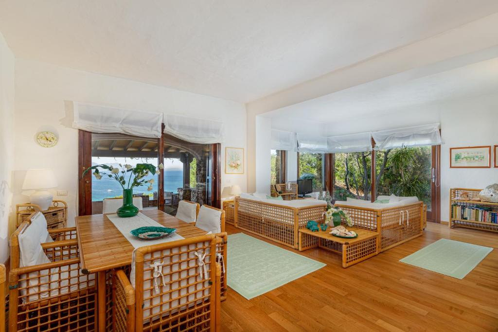 un salon avec une table et des chaises et une salle à manger dans l'établissement Villa Romantica, à Olbia