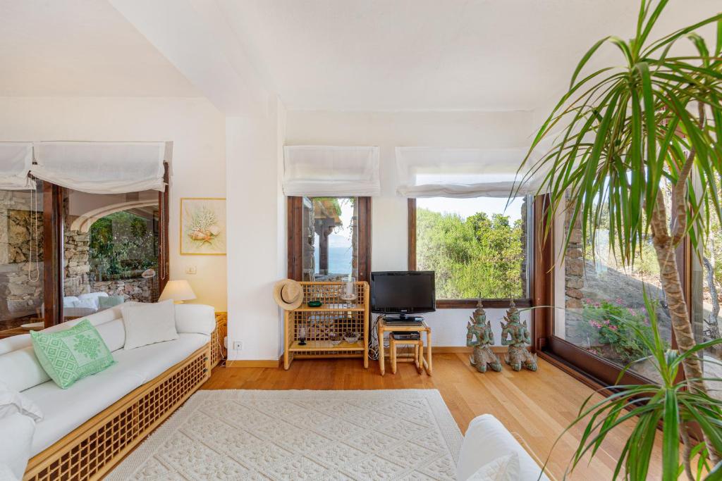 un salon avec un canapé blanc et une télévision dans l'établissement Villa Romantica, à Olbia
