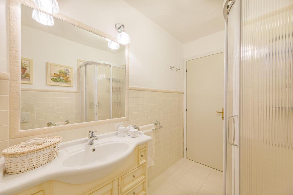 une salle de bain blanche avec un lavabo et une douche dans l'établissement Villa Romantica, à Olbia