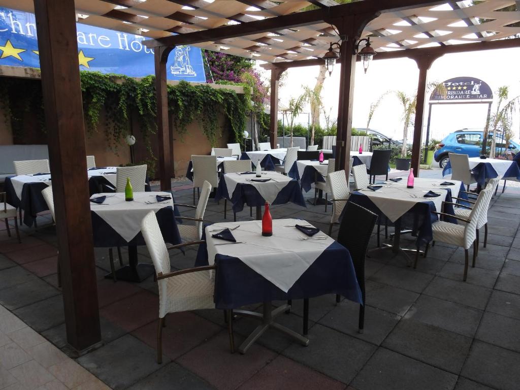 un groupe de tables et de chaises dans un restaurant dans l'établissement ChrisMare Hotel, à Mazzeo