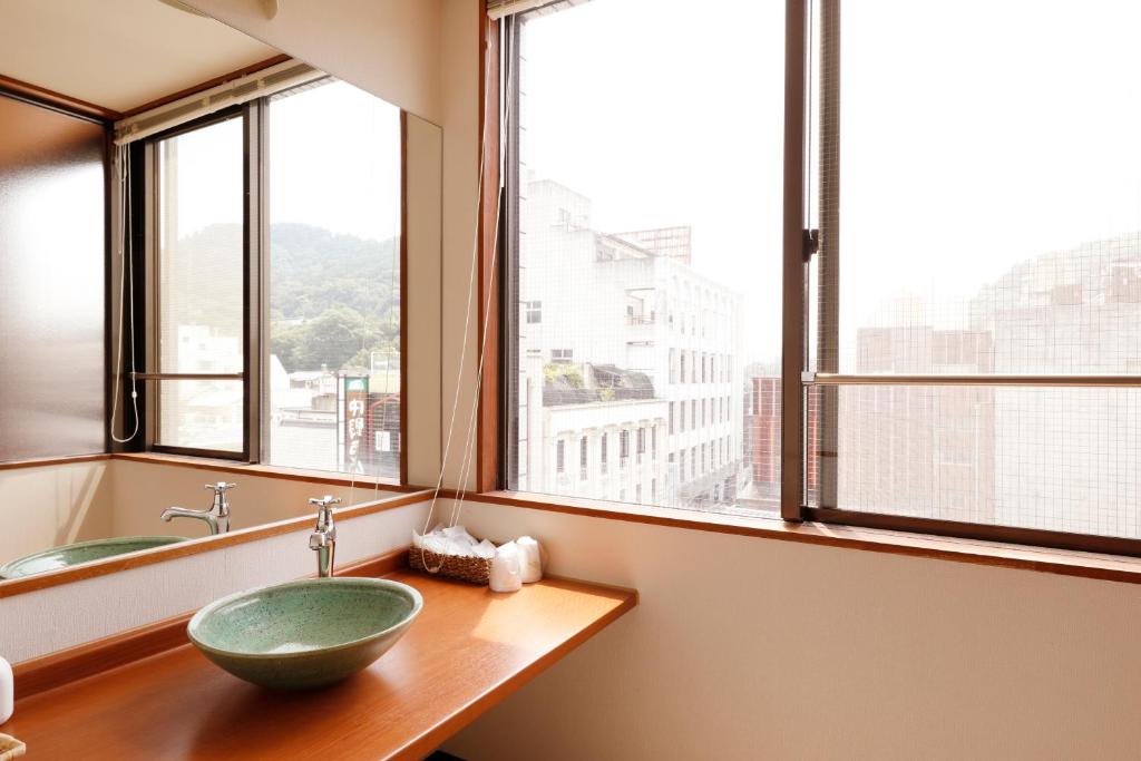une salle de bain avec un lavabo et une grande fenêtre dans l'établissement Tsuruya Ryokan, à Kotohira