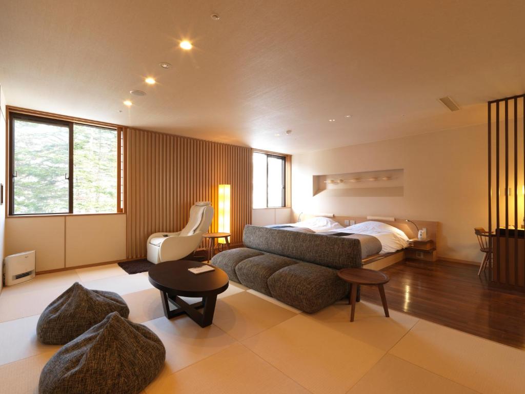 - une grande chambre avec un lit et un canapé dans l'établissement Niseko Konbu Onsen Tsuruga Moku-no-sho, à Niseko 37 autres photos