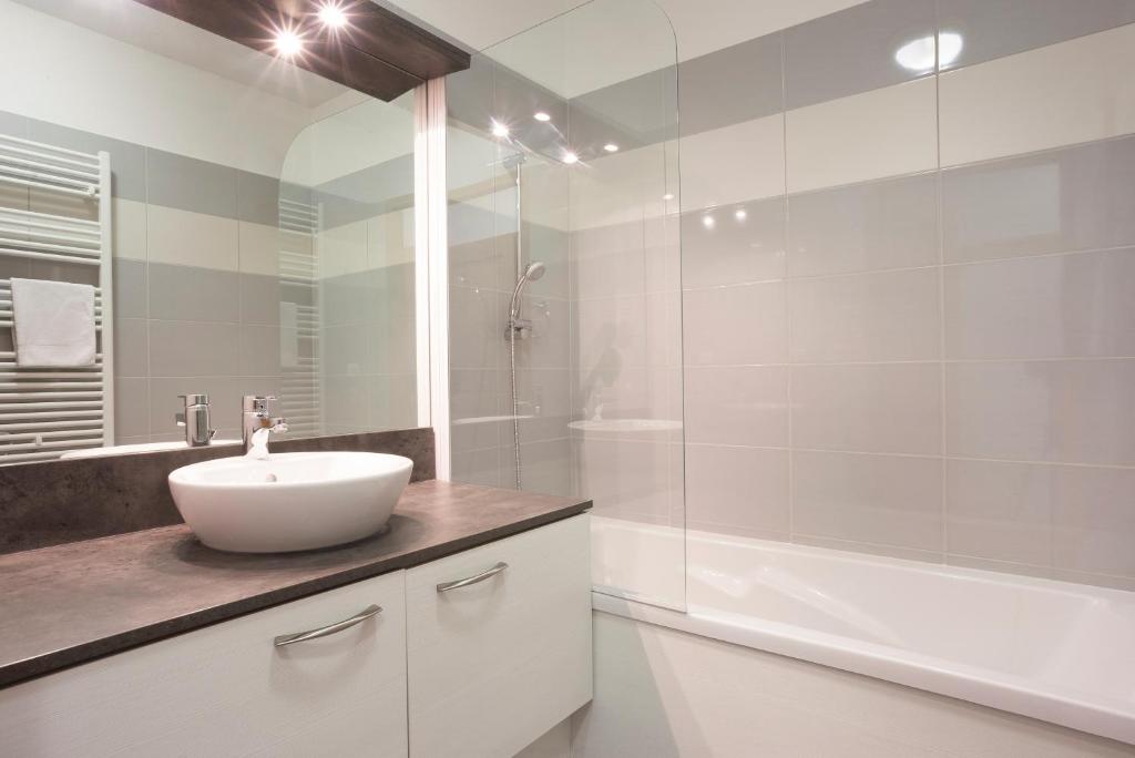 une salle de bain blanche avec un lavabo et une douche dans l'établissement Résidence Club mmv L'Étoile des Cimes ****, à Sainte-Foy-Tarentaise
