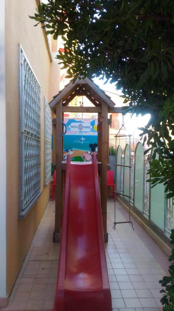 - une aire de jeux avec toboggan rouge dans un bâtiment dans l'établissement Hotel Imperiale & SPA, à Gatteo a Mare