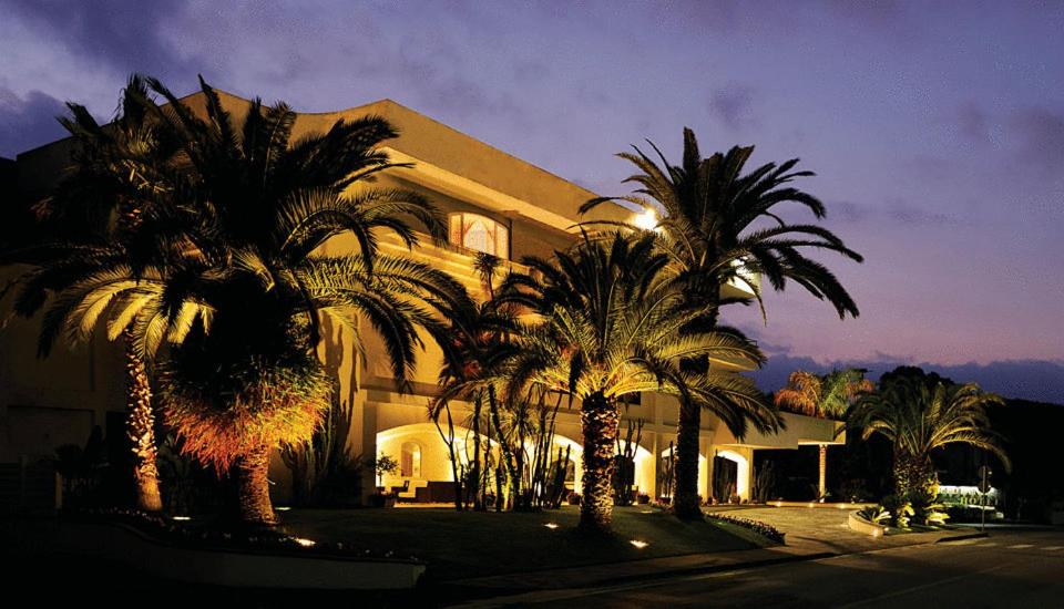 un bâtiment avec des palmiers devant dans l'établissement Hotel Meridiana, à Paestum