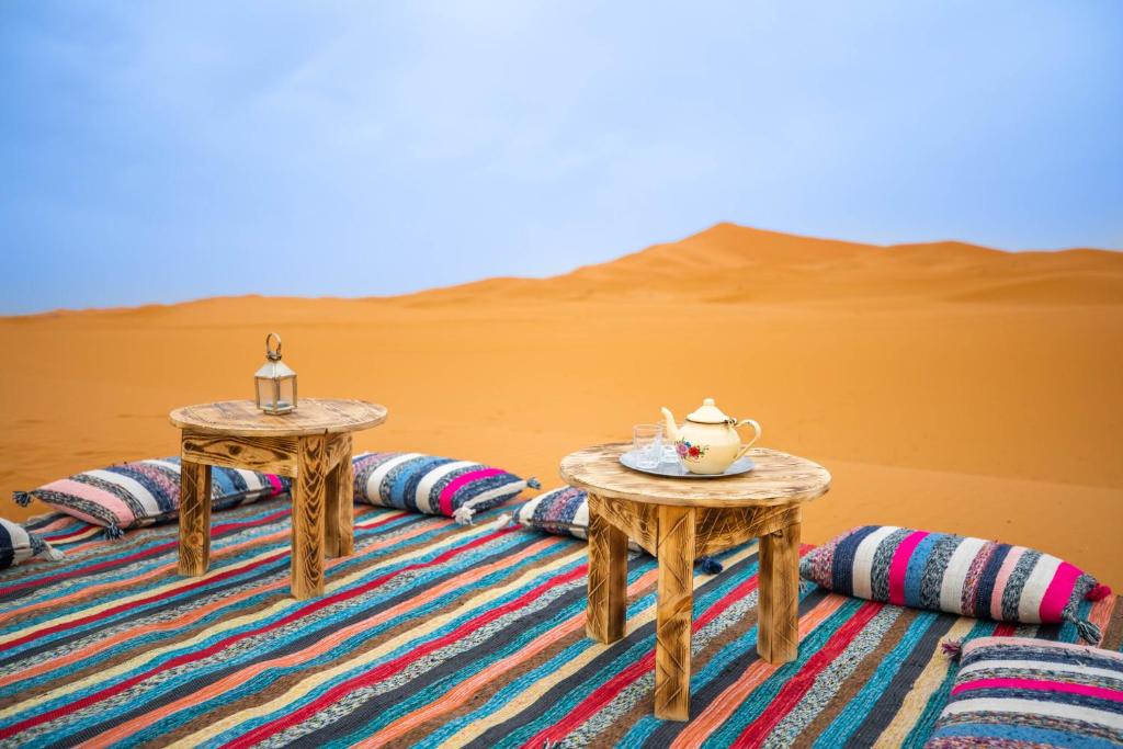 une paire de tables au milieu du désert dans l'établissement Riad Kasbah Aiour, à Merzouga