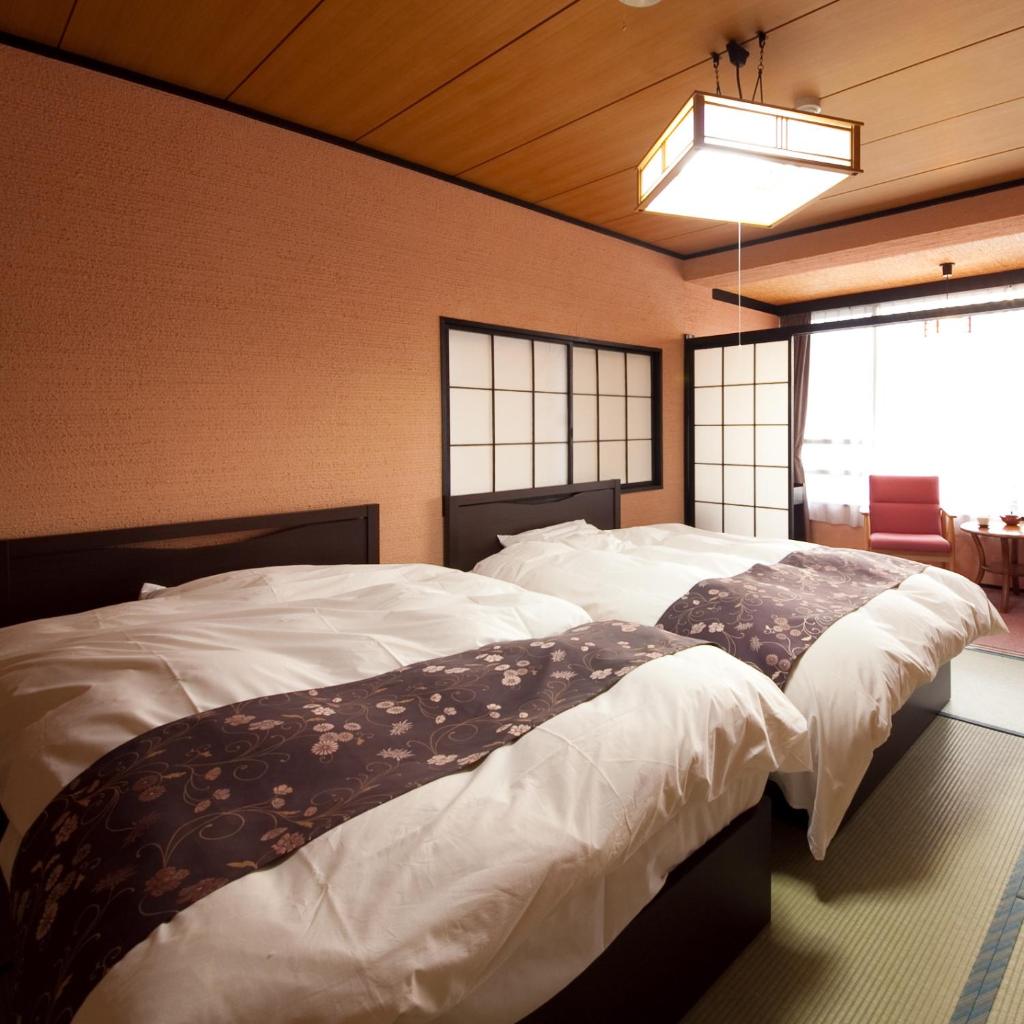 une chambre avec deux lits et une fenêtre dans l'établissement caffel Hina-no-sato, à Hita