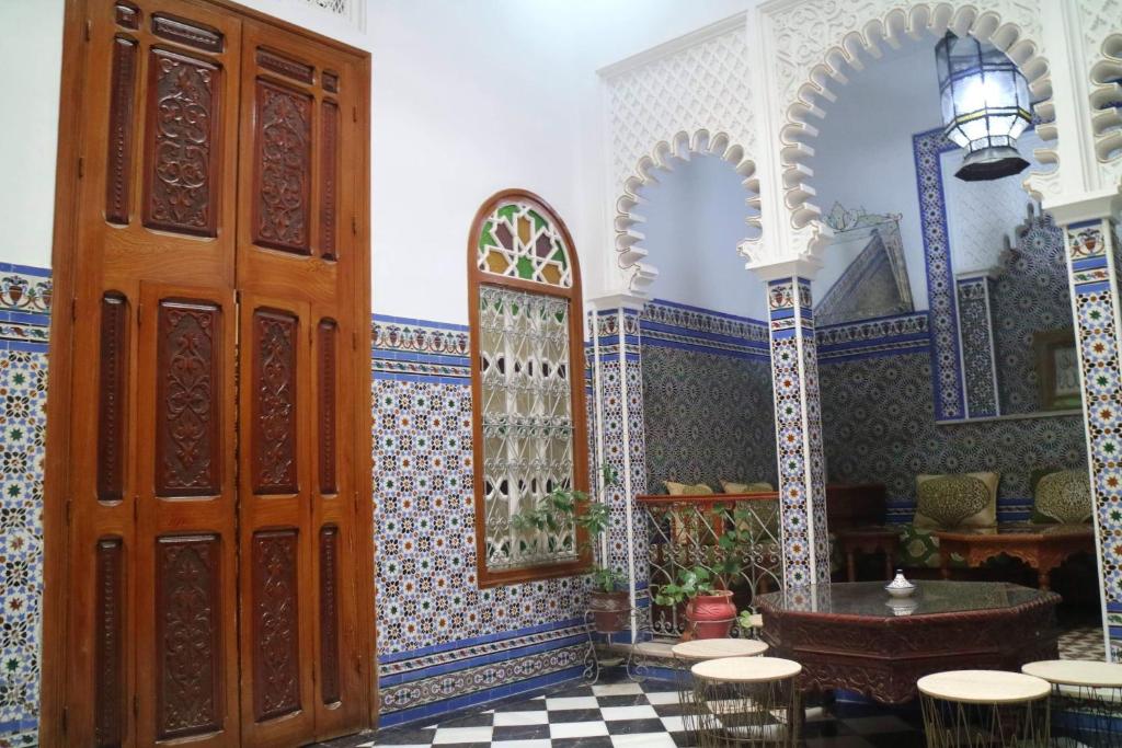 Cette chambre dispose d'une grande porte, d'une table et de chaises. dans l'établissement Riad Soul of Tetouan, à Tetouan