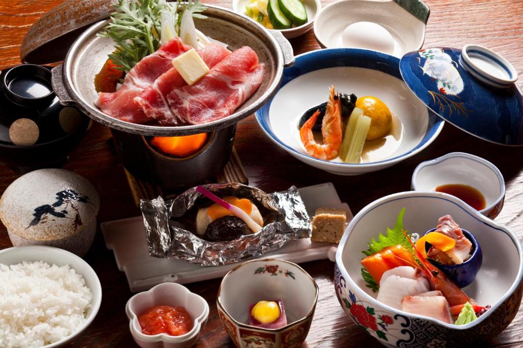 un groupe de bols de nourriture sur une table dans l'établissement Hotel Izumi, à Shiraoi