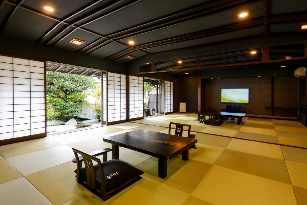 un salon avec une table et une télévision dans l'établissement Ishinoya Izunagaoka - TKP Hotels & Resorts, à Izunokuni
