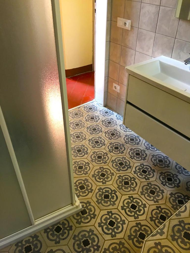 La salle de bains est pourvue d'un lavabo et de carrelage. dans l'établissement Villa Galli, à Cittiglio