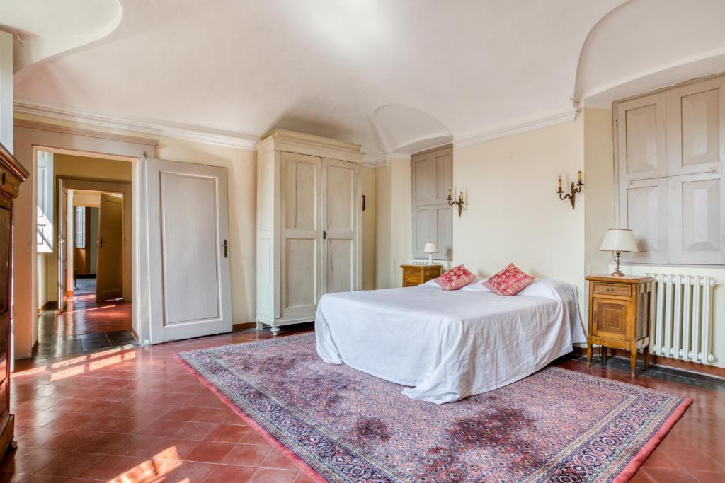 - une chambre avec un lit blanc et un tapis rose dans l'établissement Villa Galli, à Cittiglio