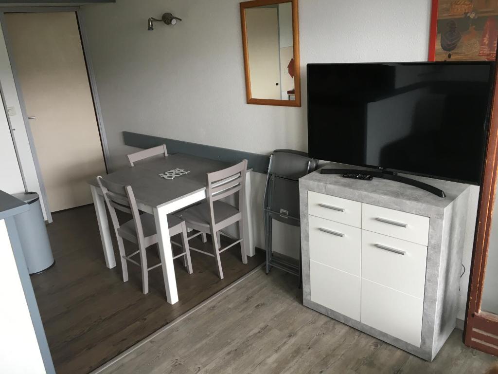 Il comprend un salon doté d'une table et d'une télévision à écran plat. dans l'établissement Appartement 5 pers Résidence Les Mélèzes quartier les Bergers Alpe d Huez, à L'Alpe-d'Huez