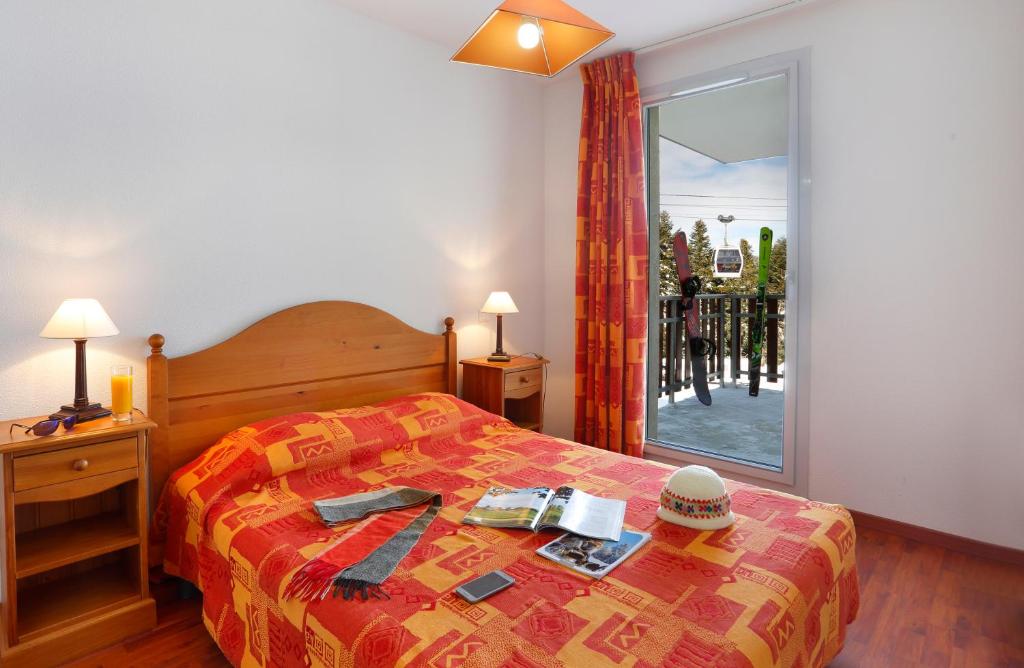 une chambre avec un lit et une grande fenêtre dans l'établissement Résidence Néméa Les Balcons d'Ax, à Ax-les-Thermes