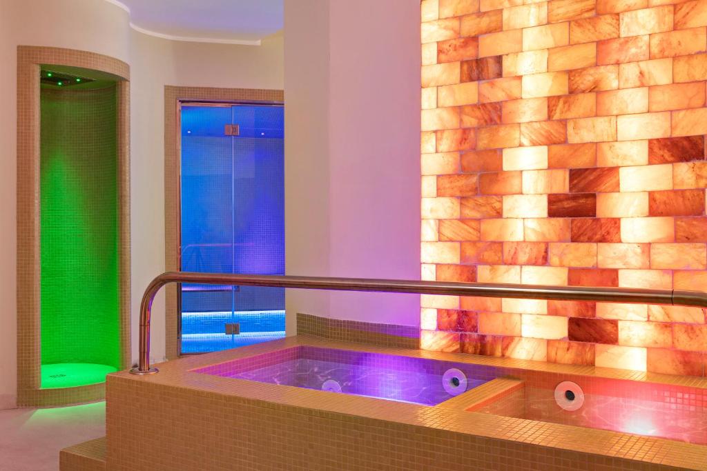 une salle de bains avec un jacuzzi à côté d'une fenêtre dans l'établissement Les Sables Noirs & Spa, à Vulcano
