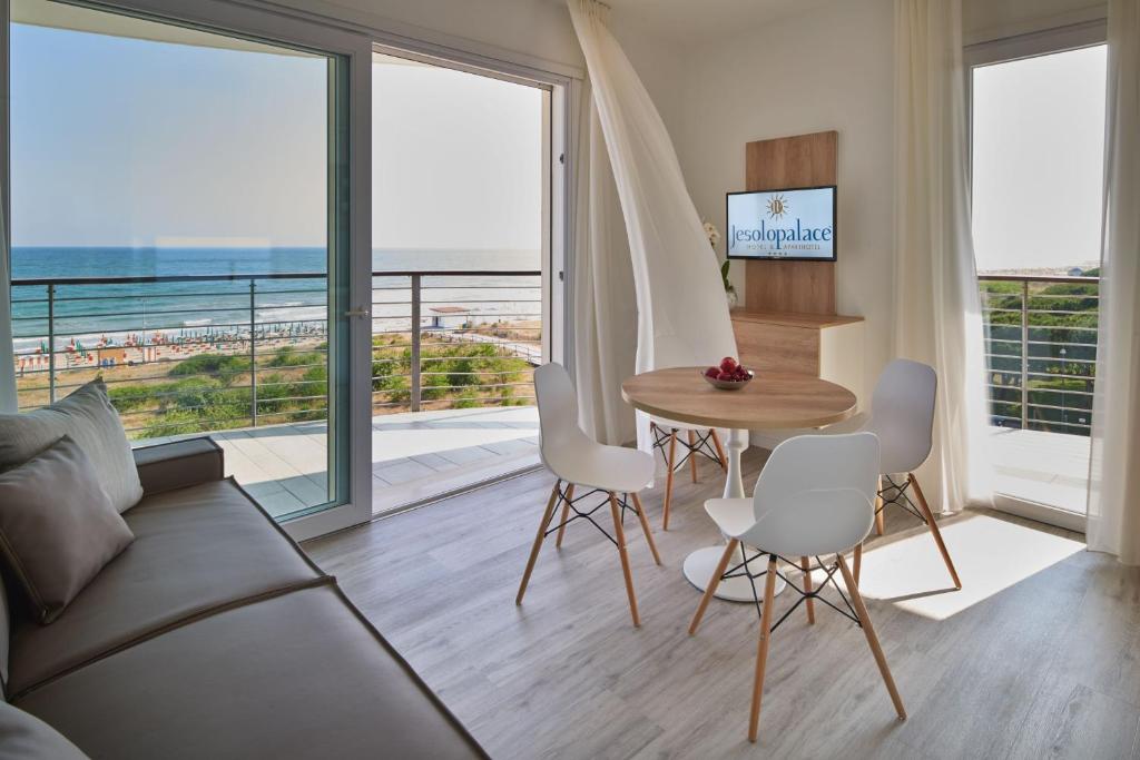 un salon avec un canapé et une table avec des chaises dans l'établissement Jesolopalace Hotel & Aparthotel, à Lido di Jesolo