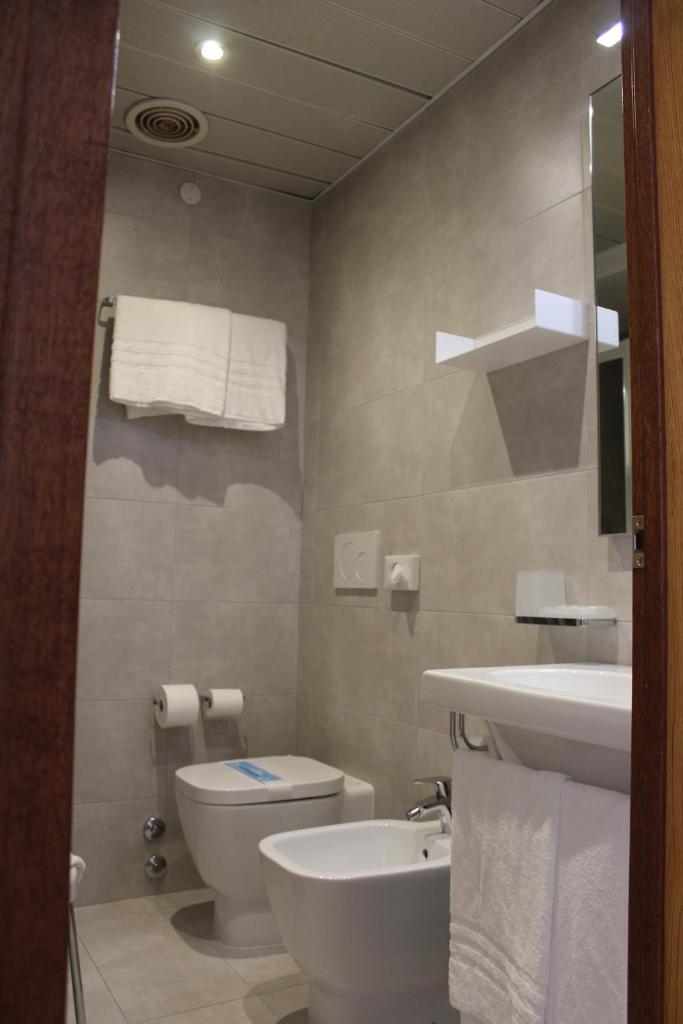une salle de bain avec toilettes et lavabo dans l'établissement Hotel Bristol, à Lignano Sabbiadoro