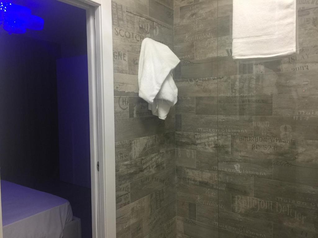 La salle de bains est pourvue d'une serviette accrochée au mur. dans l'établissement Hotel Riva Del Sole, à Porto Cesareo