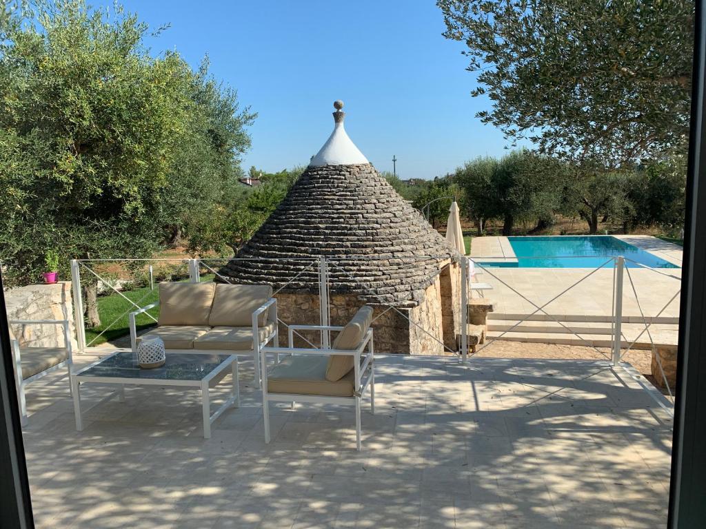 un patio avec une table et des chaises à côté d'un bâtiment dans l'établissement Residenza Lippolis, à Castellana Grotte