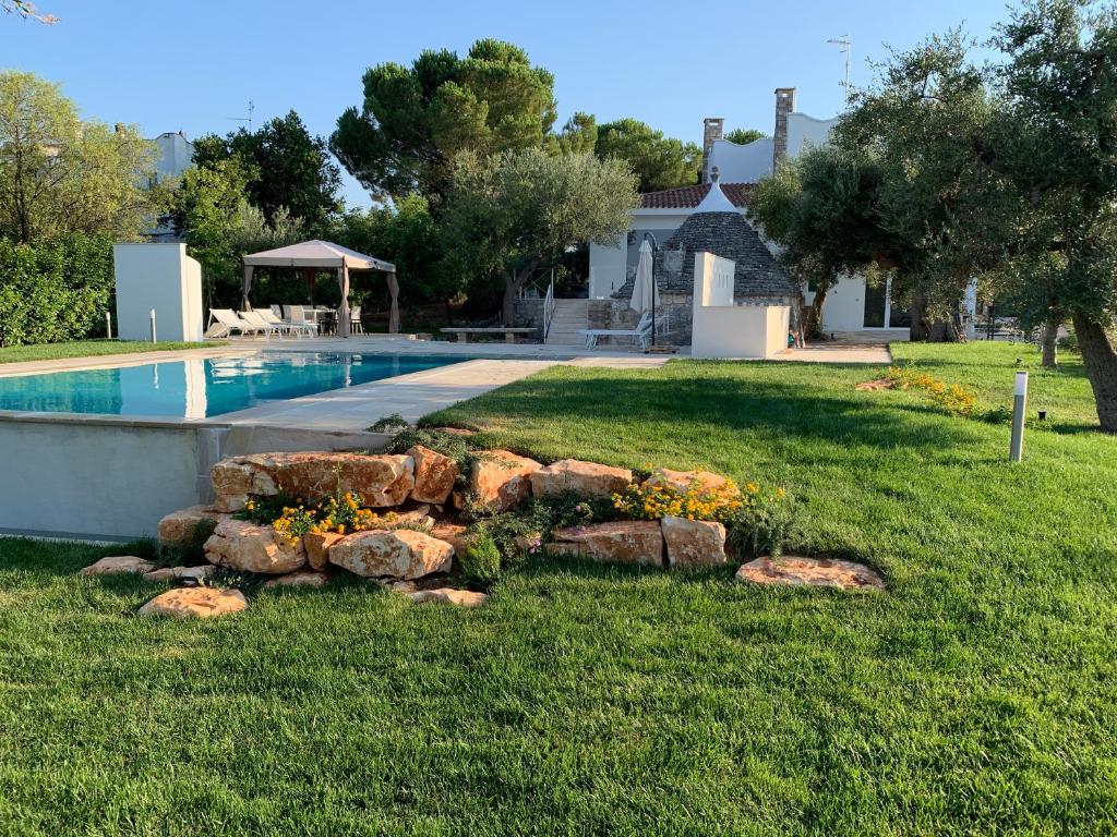 une cour avec une piscine et quelques rochers dans l'établissement Residenza Lippolis, à Castellana Grotte