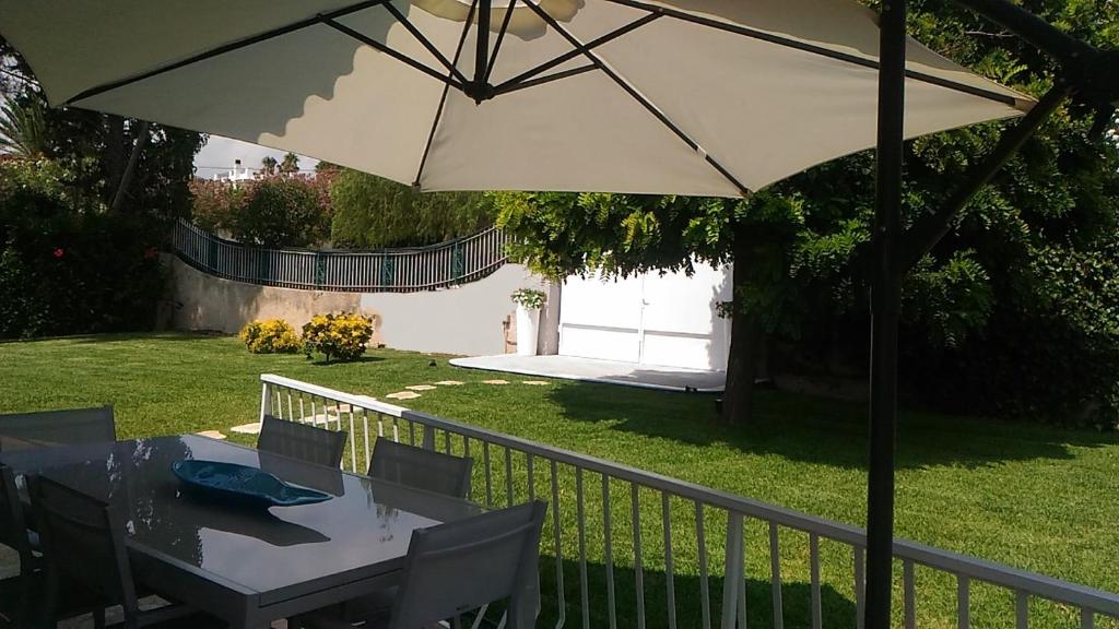 - une table avec un parasol dans la cour dans l'établissement Villa delle Muse, à Fontane Bianche